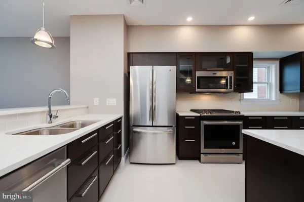 a kitchen with stainless steel appliances a sink stove and refrigerator