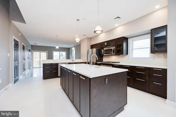 a kitchen with stainless steel appliances kitchen island granite countertop a stove a sink and a refrigerator