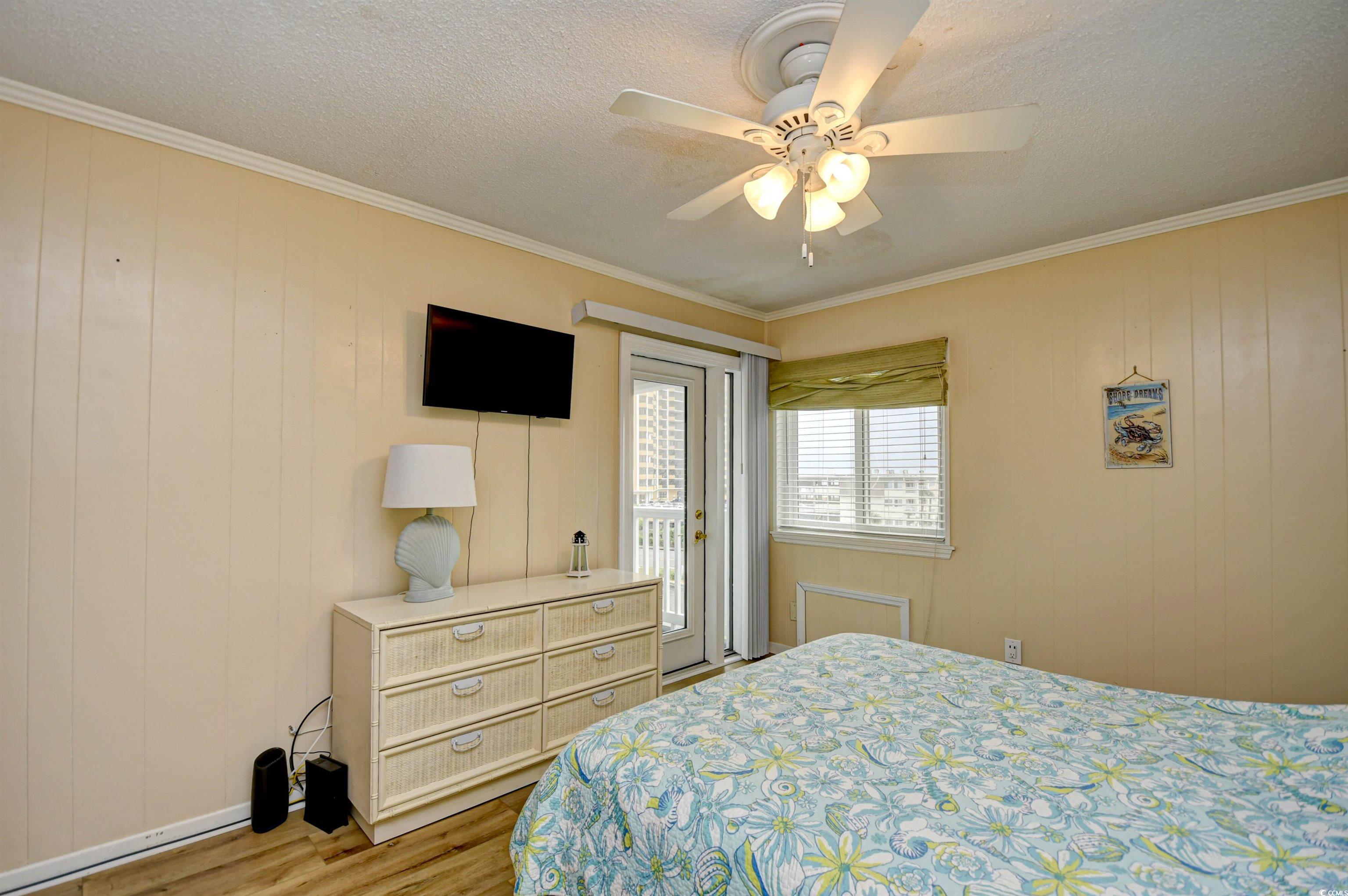 191 Maison Drive, Unit B211 Myrtle Beach, SC 29572 - Photo 15 of 35 Bedroom with crown molding, access to outside, wood finished floors, ceiling fan, and a textured ceiling