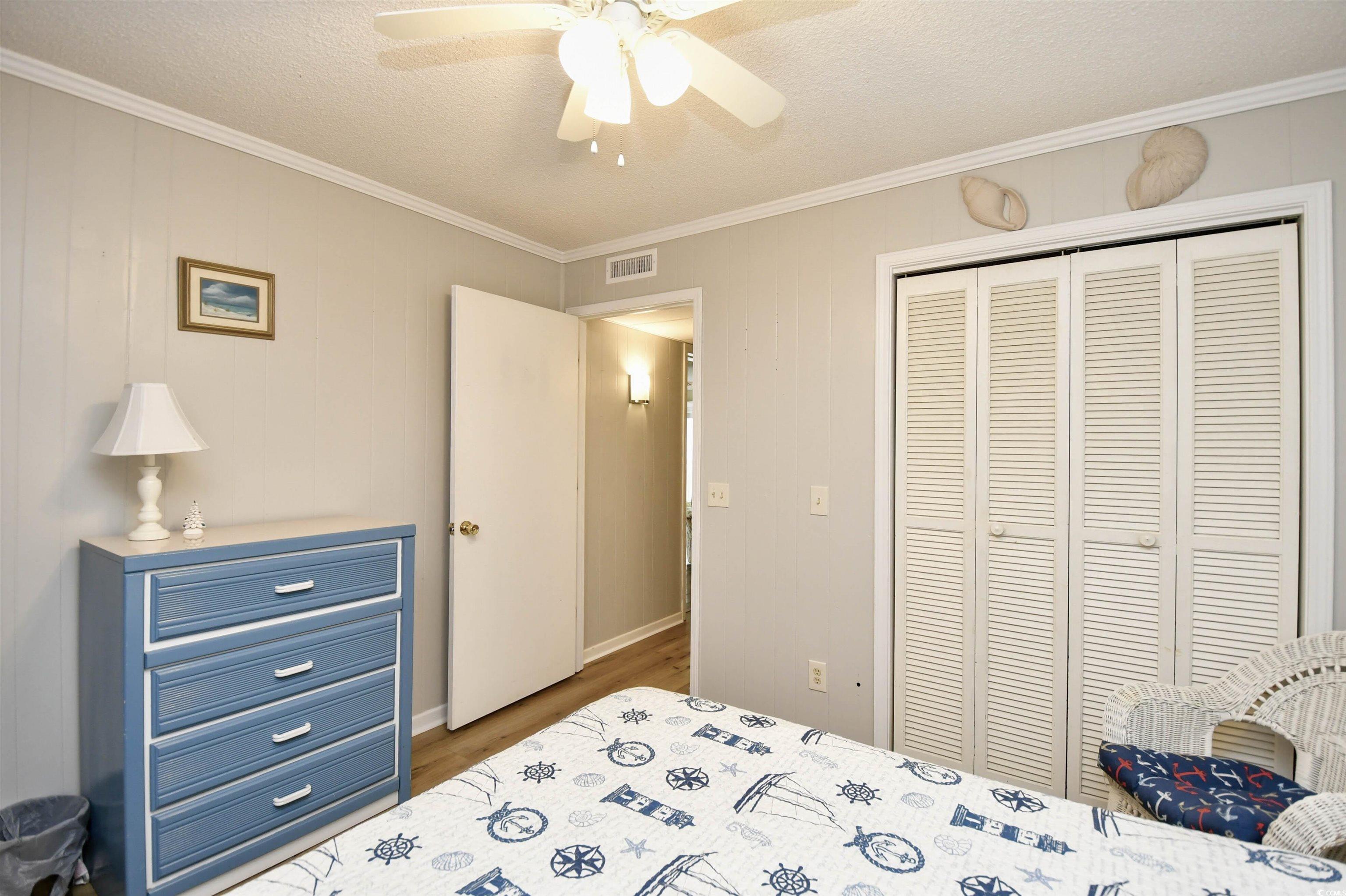 191 Maison Drive, Unit B211 Myrtle Beach, SC 29572 - Photo 20 of 35 Bedroom featuring crown molding, wood finished floors, a closet, a textured ceiling, and a ceiling fan