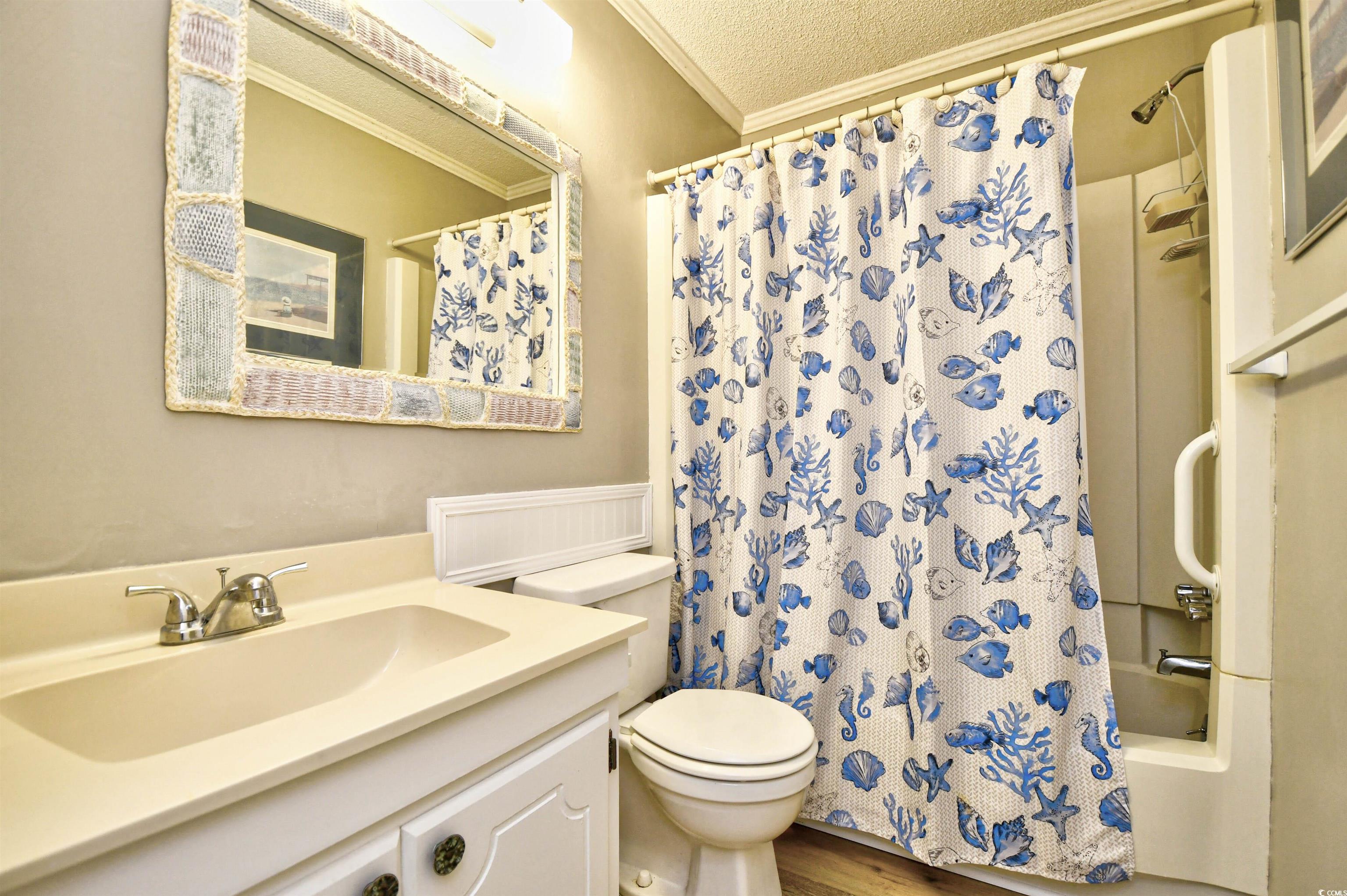191 Maison Drive, Unit B211 Myrtle Beach, SC 29572 - Photo 21 of 35 Bathroom with ornamental molding, vanity, shower / bath combo with shower curtain, wood finished floors, and a textured ceiling