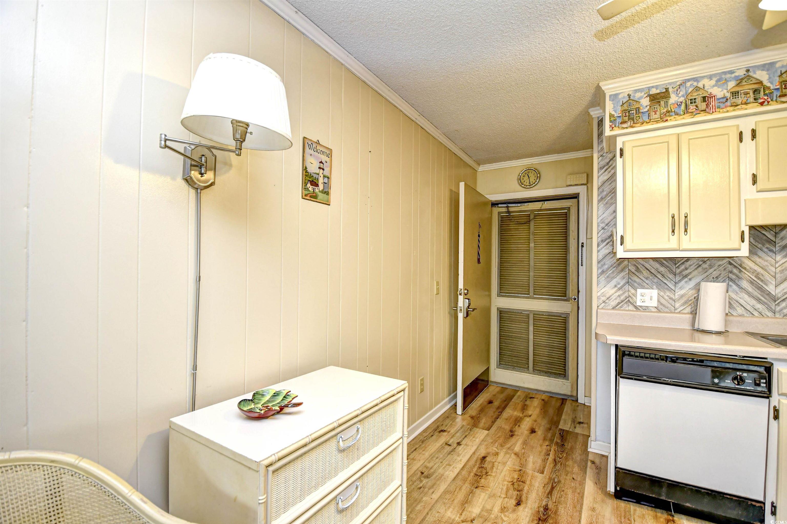 191 Maison Drive, Unit B211 Myrtle Beach, SC 29572 - Photo 3 of 35 Kitchen with ornamental molding, dishwasher, light wood finished floors, light countertops, and a textured ceiling