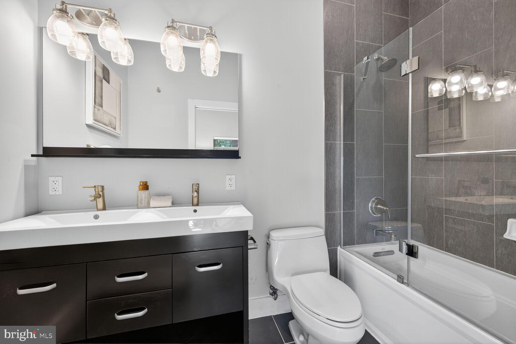 762 Park Road Northwest, Unit 7 Washington, DC 20010 - Photo 15 of 33 a bathroom with a toilet a sink a mirror a bathtub and vanity