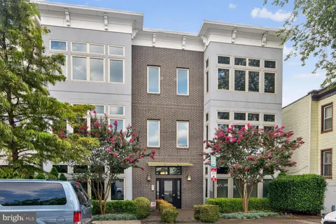 a front view of a building with a garden and plants