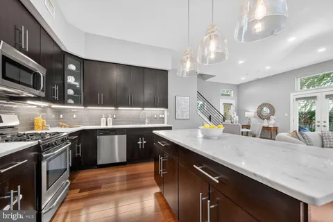a kitchen with stainless steel appliances a sink cabinets and a stove top oven