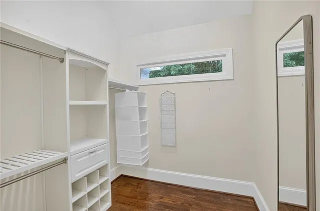 a spacious bathroom with a granite countertop sink a toilet a mirror and shower