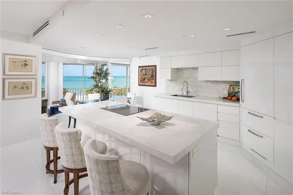 a kitchen with a sink a stove a refrigerator and white cabinets with wooden floor