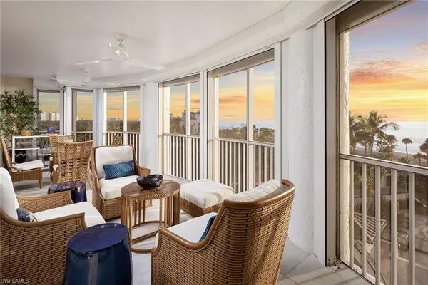 a balcony with furniture and large windows