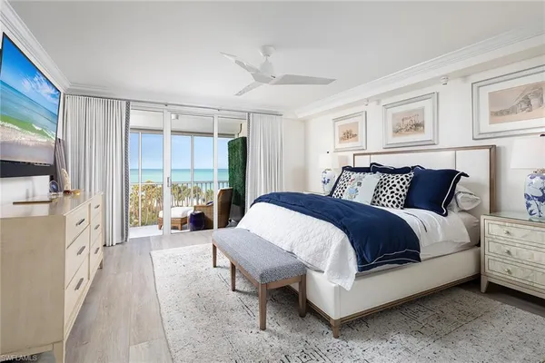 a spacious bedroom with a bed and a flat tv screen