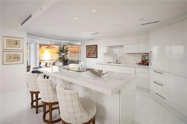 a kitchen with stainless steel appliances kitchen island granite countertop a sink cabinets and wooden floor