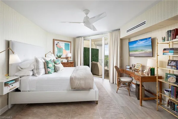 a bedroom with a bed wooden floor and a large window