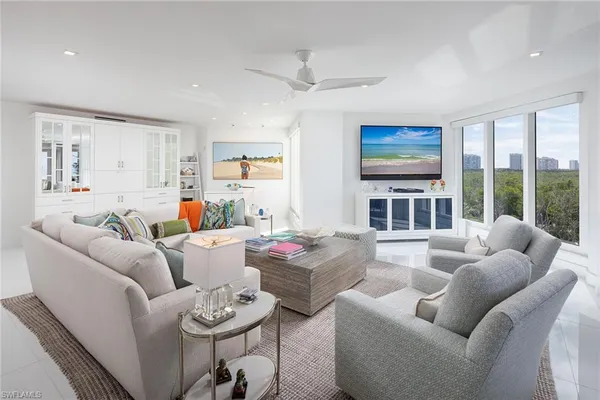 a living room with furniture large window and flat screen tv