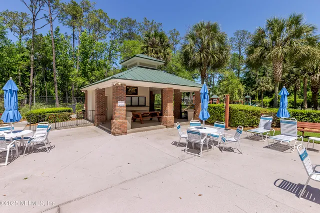 a view of a patio with a table and chairs under an umbrella
