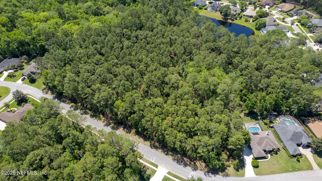 an aerial view of residential house with outdoor space and trees all around
