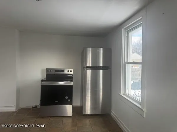 a room with refrigerator and window