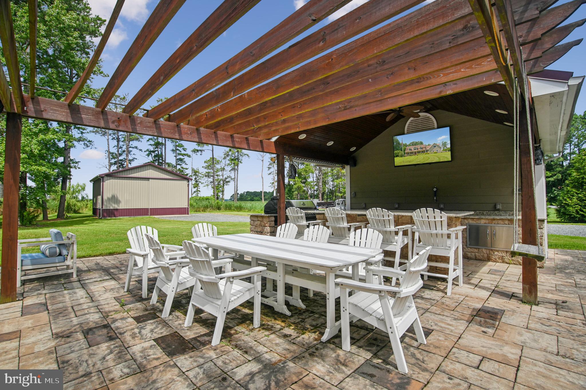 6670 Tilghman Island Road Sherwood, MD 21665 - Photo 18 of 64 a view of a patio with a dining table and chairs with a backyard