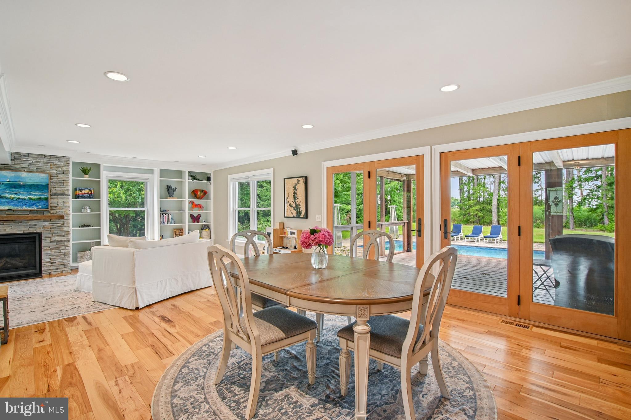 6670 Tilghman Island Road Sherwood, MD 21665 - Photo 40 of 64 a view of a dining room with furniture large windows and wooden floor