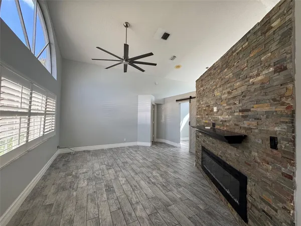 a view of a livingroom with wooden floor and a ceiling fan