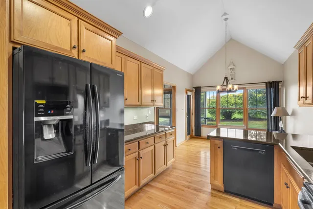 a kitchen with stainless steel appliances granite countertop a refrigerator a sink and a stove