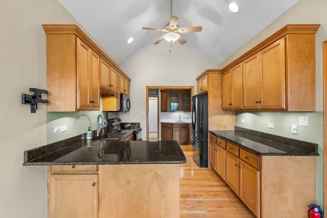 a kitchen with stainless steel appliances granite countertop a sink a stove counter space and cabinets
