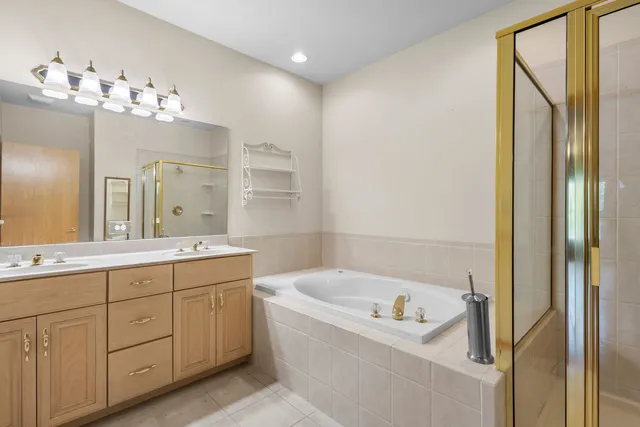 a bathroom with a tub sink and mirror