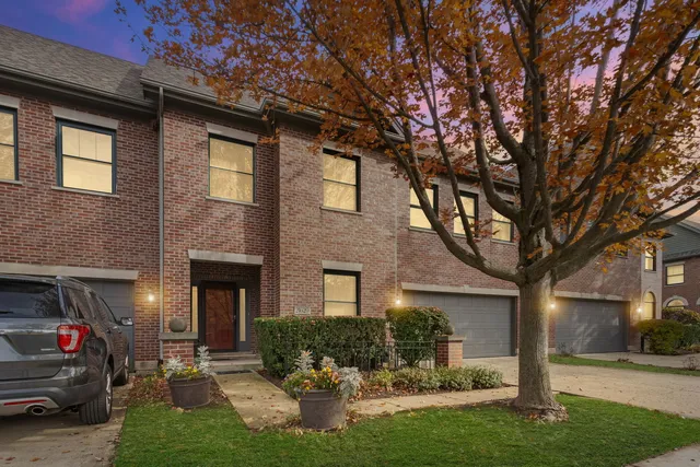 a front view of a house with yard and green space