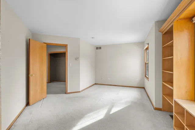 an empty room with windows and fireplace