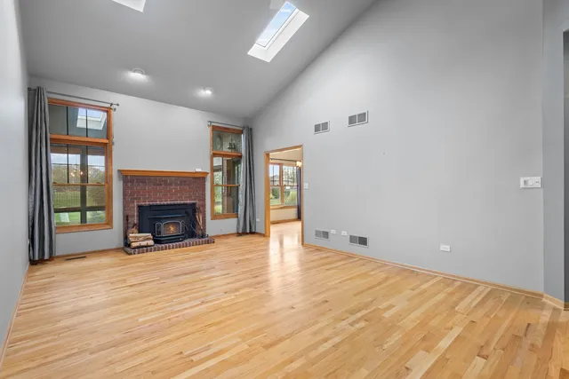 a view of empty room with wooden floor and fireplace