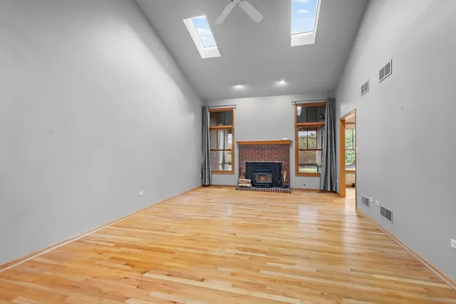 a view of empty room with wooden floor fireplace and windows