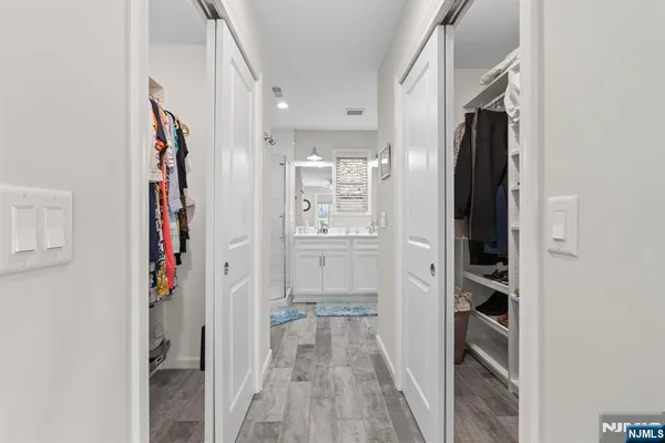 a view of a hallway with wooden floor and closet