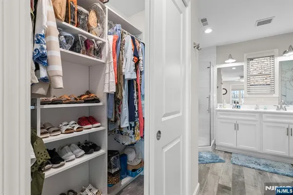 a view of walk in closet with clothes and shoes