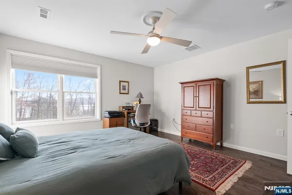 a large bedroom with a bed and wooden floor