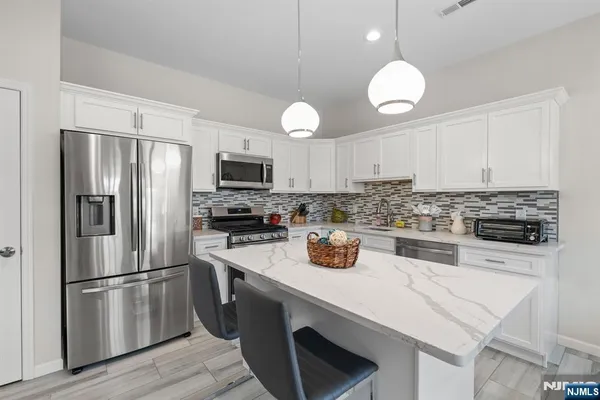 a kitchen with a refrigerator a microwave a stove and cabinets