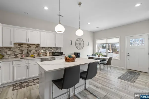 a view of a dining room and kitchen with a table chairs and chandelier