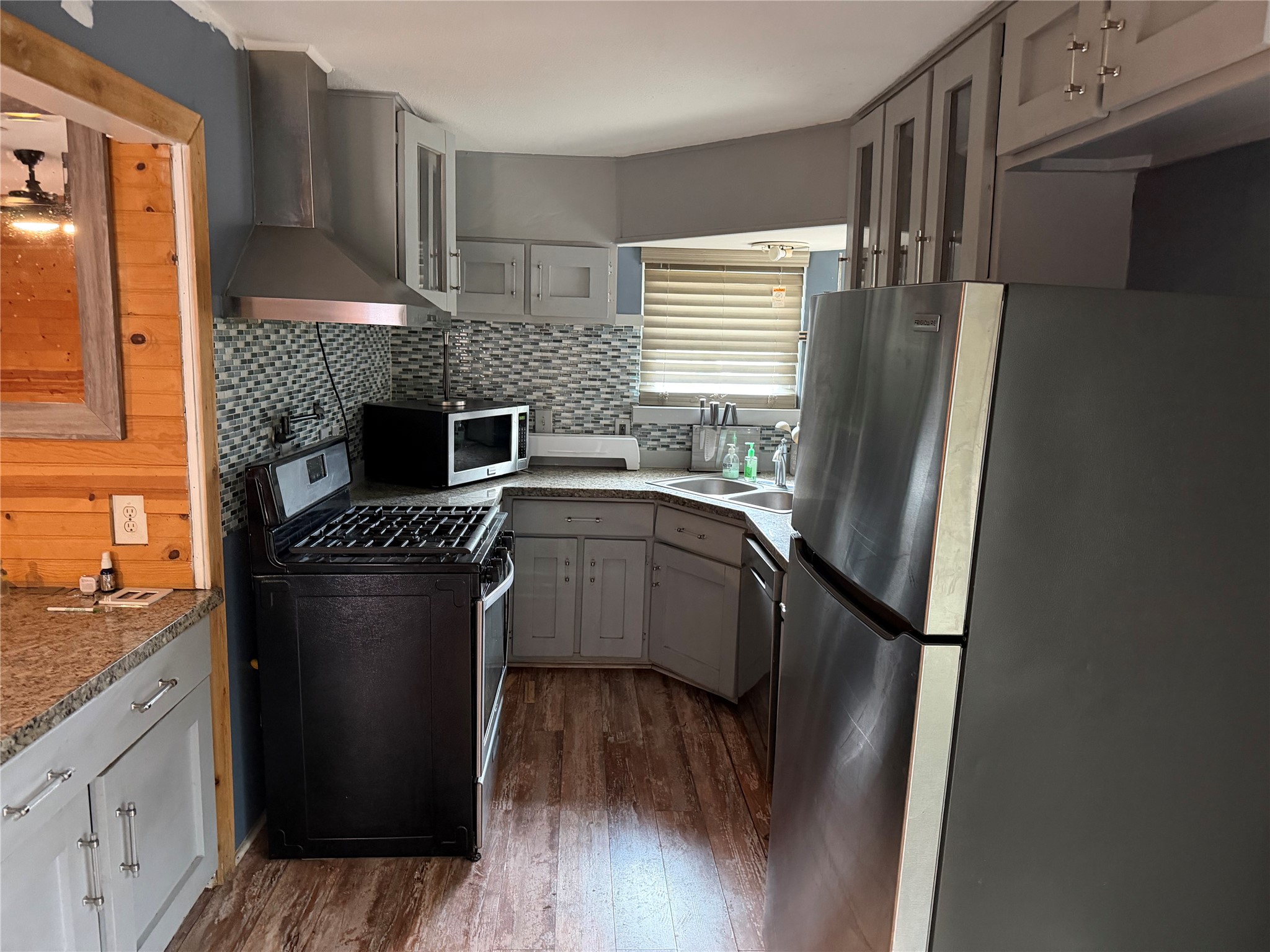 6811 St Augustine Street Houston, TX 77021 - Photo 5 of 20 a kitchen with stainless steel appliances granite countertop a refrigerator a sink dishwasher a stove and white countertops with wooden floor