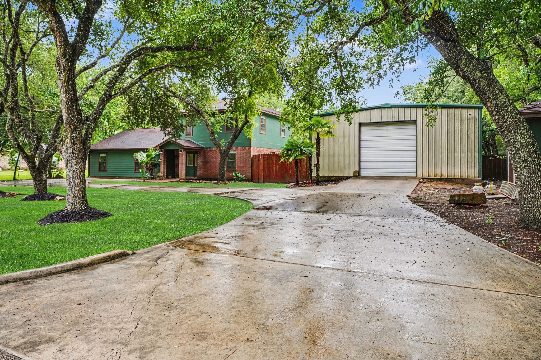 5104 Avenue R Santa Fe, TX 77510 - Photo 4 of 35 Features a spacious driveway leading to a large detached 30x4 insulated workshop, perfect for extra storage or projects.