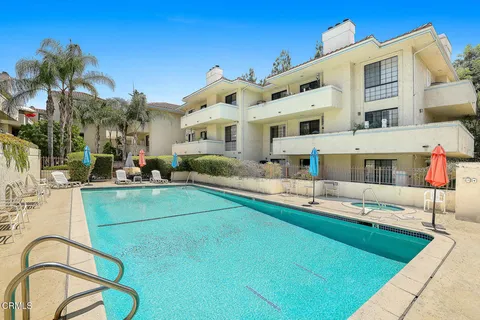 a view of a building with a swimming pool and sitting area