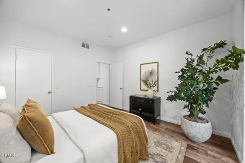 a bedroom with a bed and a potted plant