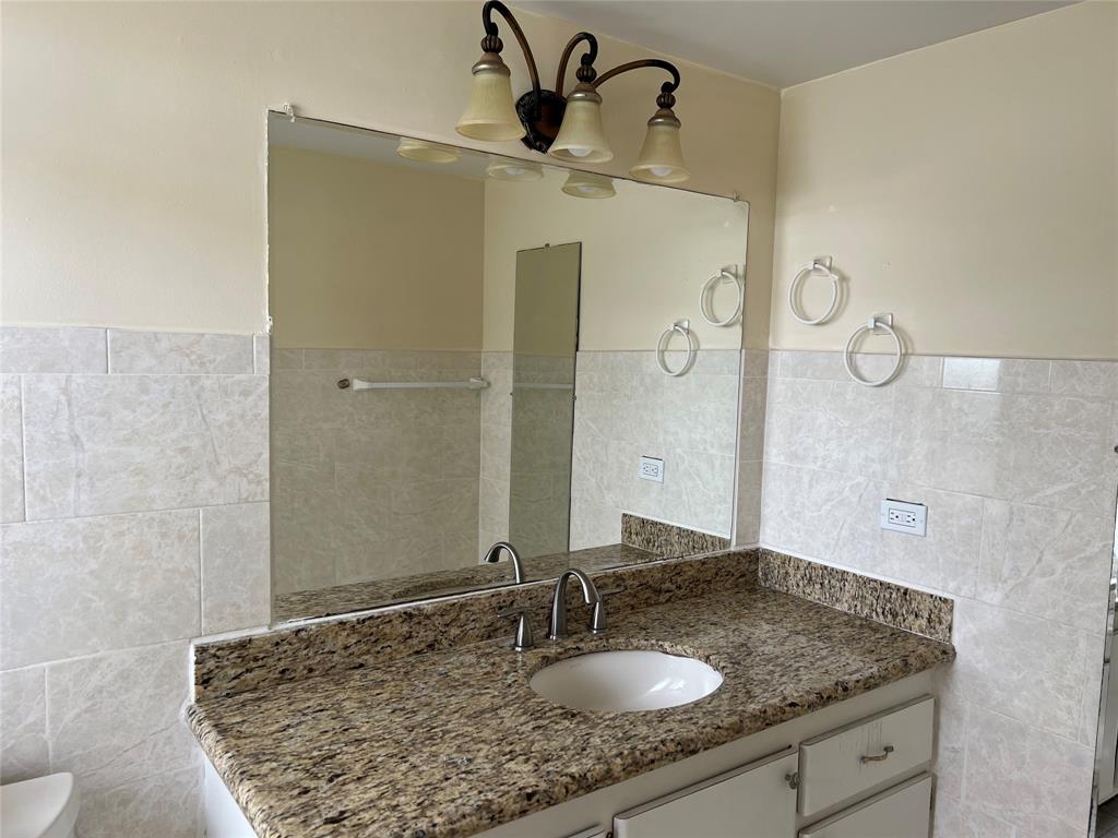 Royal Oaks Miami, FL 33179 - Photo 4 of 9 a bathroom with a granite countertop sink and a mirror