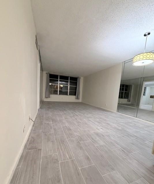 9949 Sandalfoot Boulevard, Unit 542 Boca Raton, FL 33428 - Photo 6 of 9 an empty room with wooden floor and window