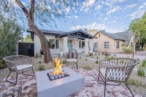 a outdoor space with patio the couches and a fireplace with the potted plants