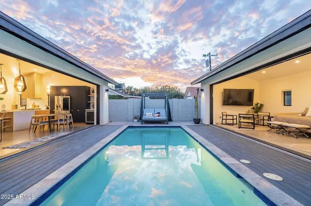 a swimming pool with chairs and wooden floor