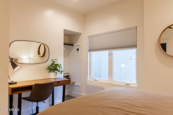 a bedroom with a bed and a painting on the wall