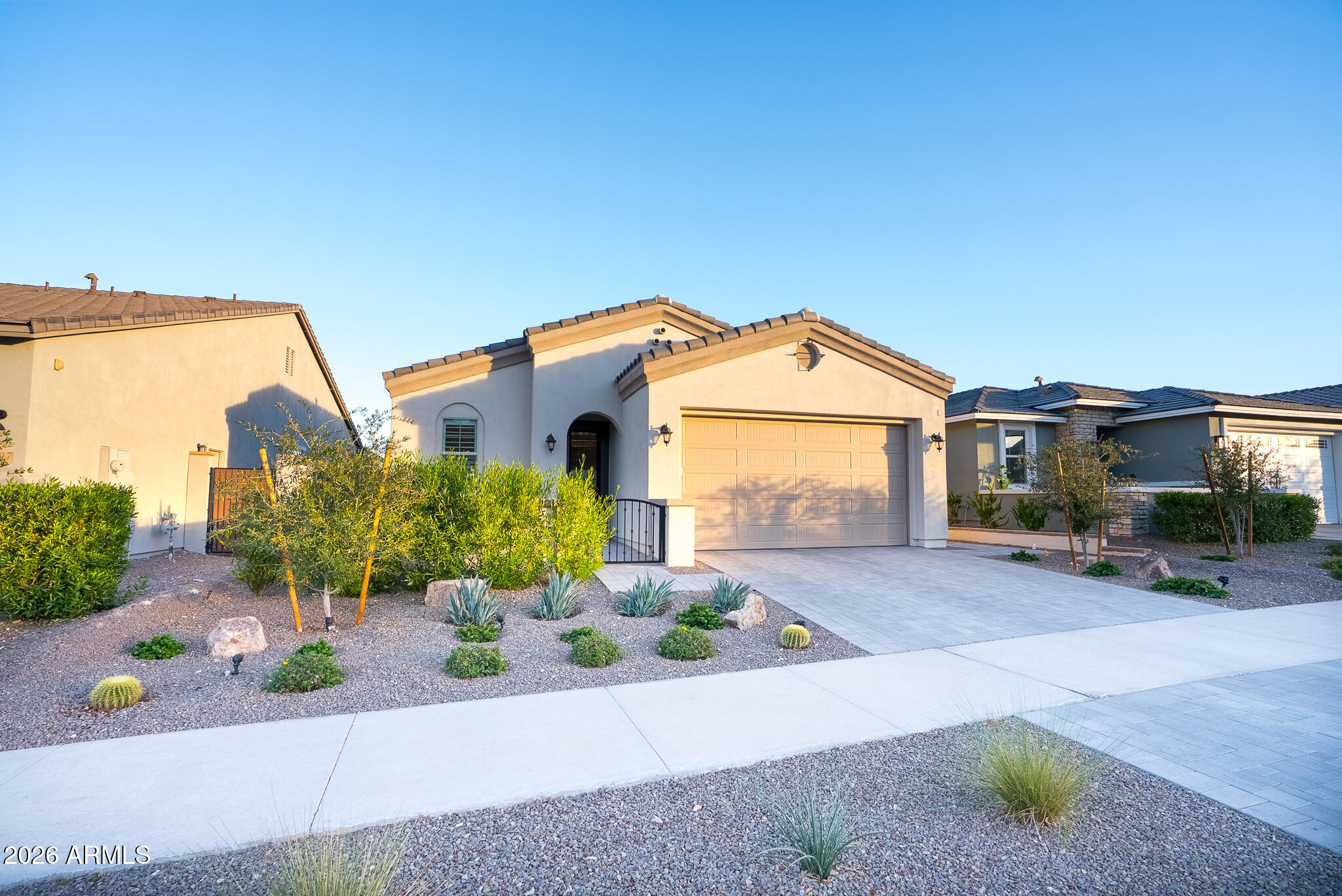 5693 206th Lane Buckeye, AZ 85396 - Photo 2 of 33 a front view of a house with a yard and potted plants
