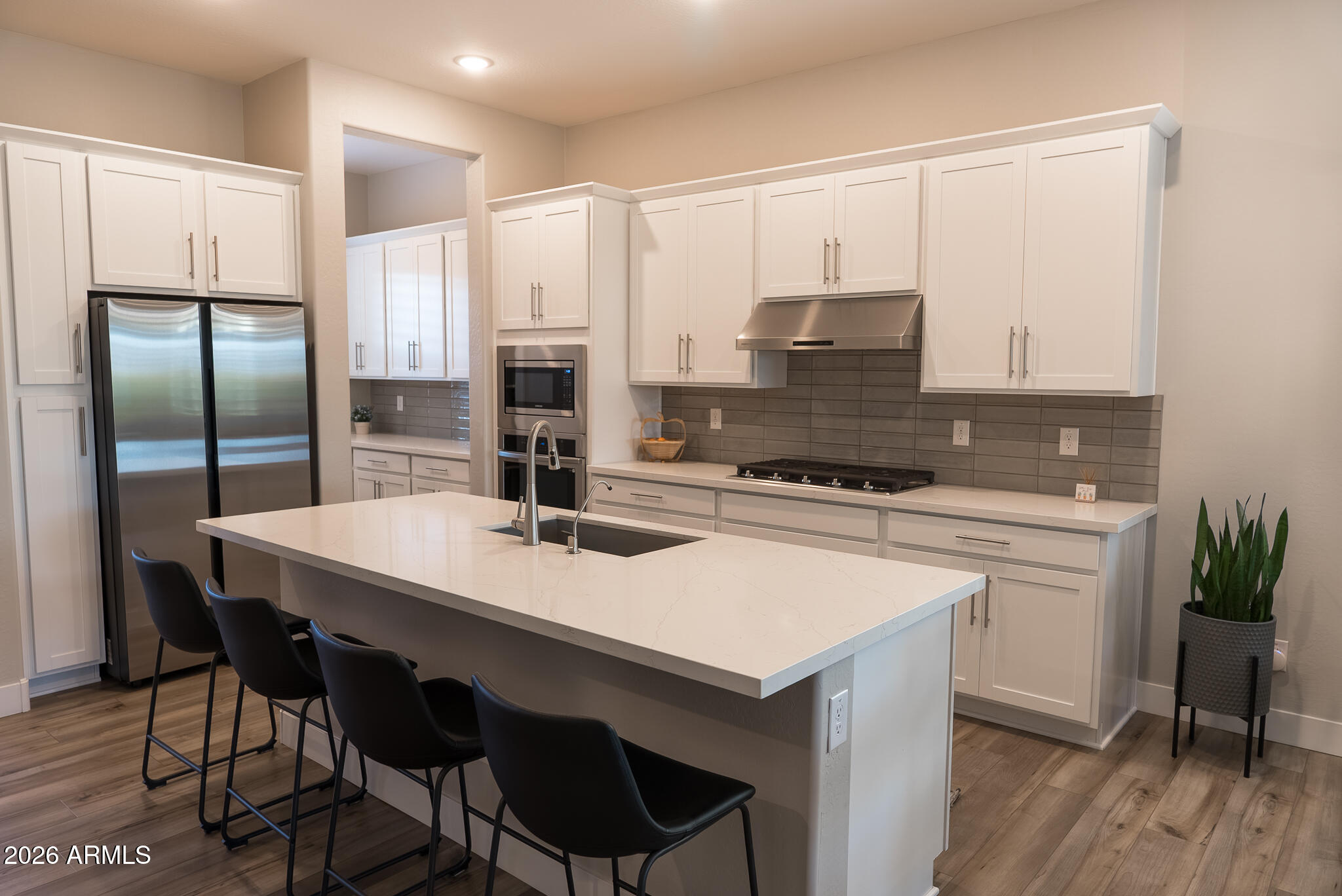 5693 206th Lane Buckeye, AZ 85396 - Photo 8 of 33 a kitchen with stainless steel appliances white cabinets and wooden floor