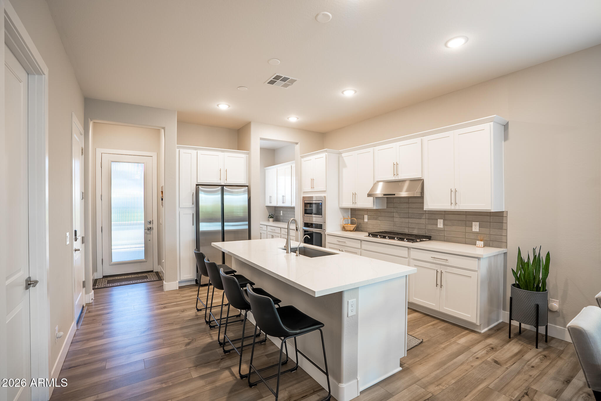 5693 206th Lane Buckeye, AZ 85396 - Photo 9 of 33 a kitchen with a stove a refrigerator and a dining table