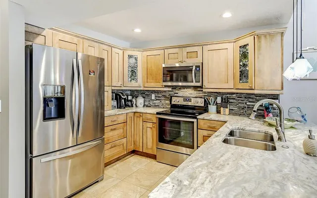 a kitchen with stainless steel appliances granite countertop a refrigerator stove microwave and sink