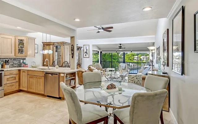 a very nice looking open dining room with kitchen island furniture a large window and kitchen view