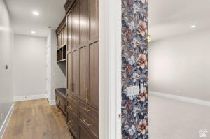 1141 East Lost Ridge Drive Washington, UT 84780 - Photo 89 of 108 Hallway featuring wood-finish flooring, recessed lighting, and built-in wood cabinetry with gold-tone hardware and integrated seating