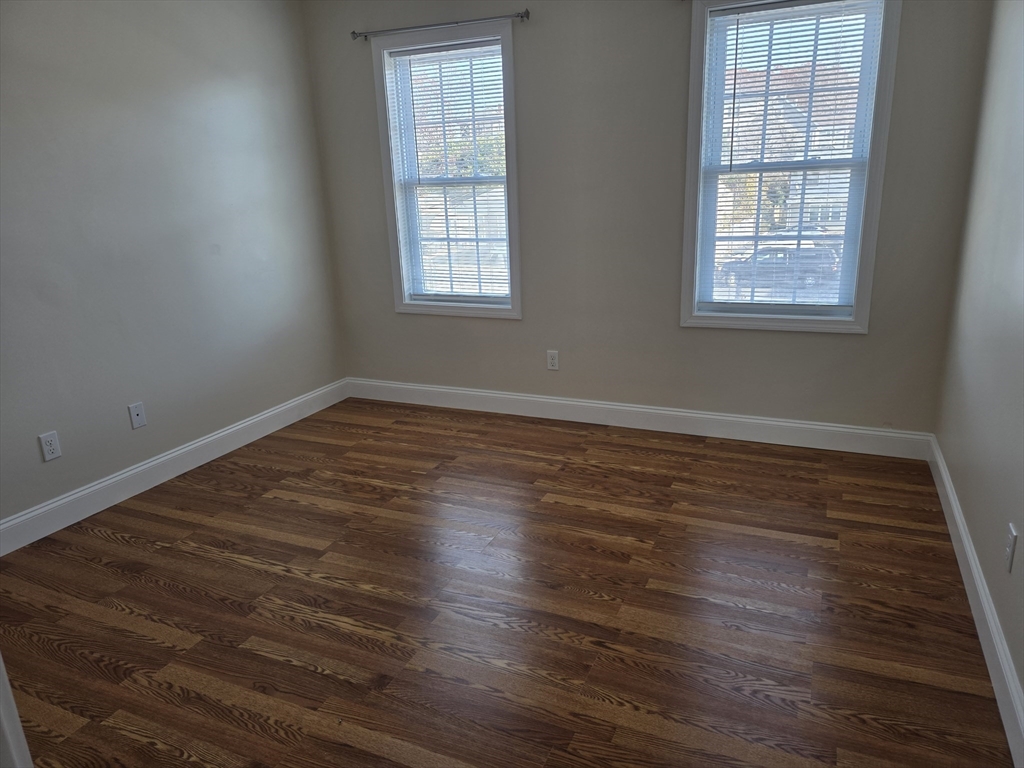 176 Oak Grove Avenue Fall River, MA 02723 - Photo 5 of 9 an empty room with wooden floor and windows